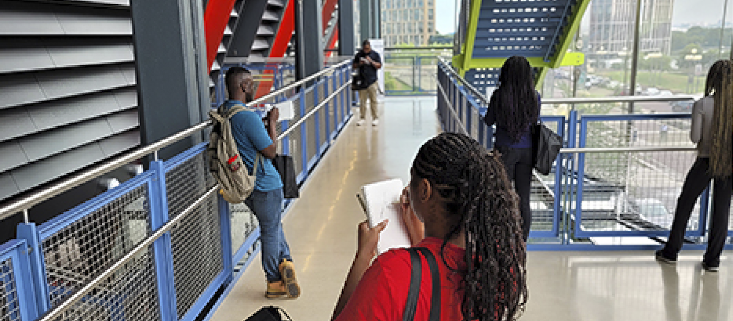 Students writing in notebooks at a job site.